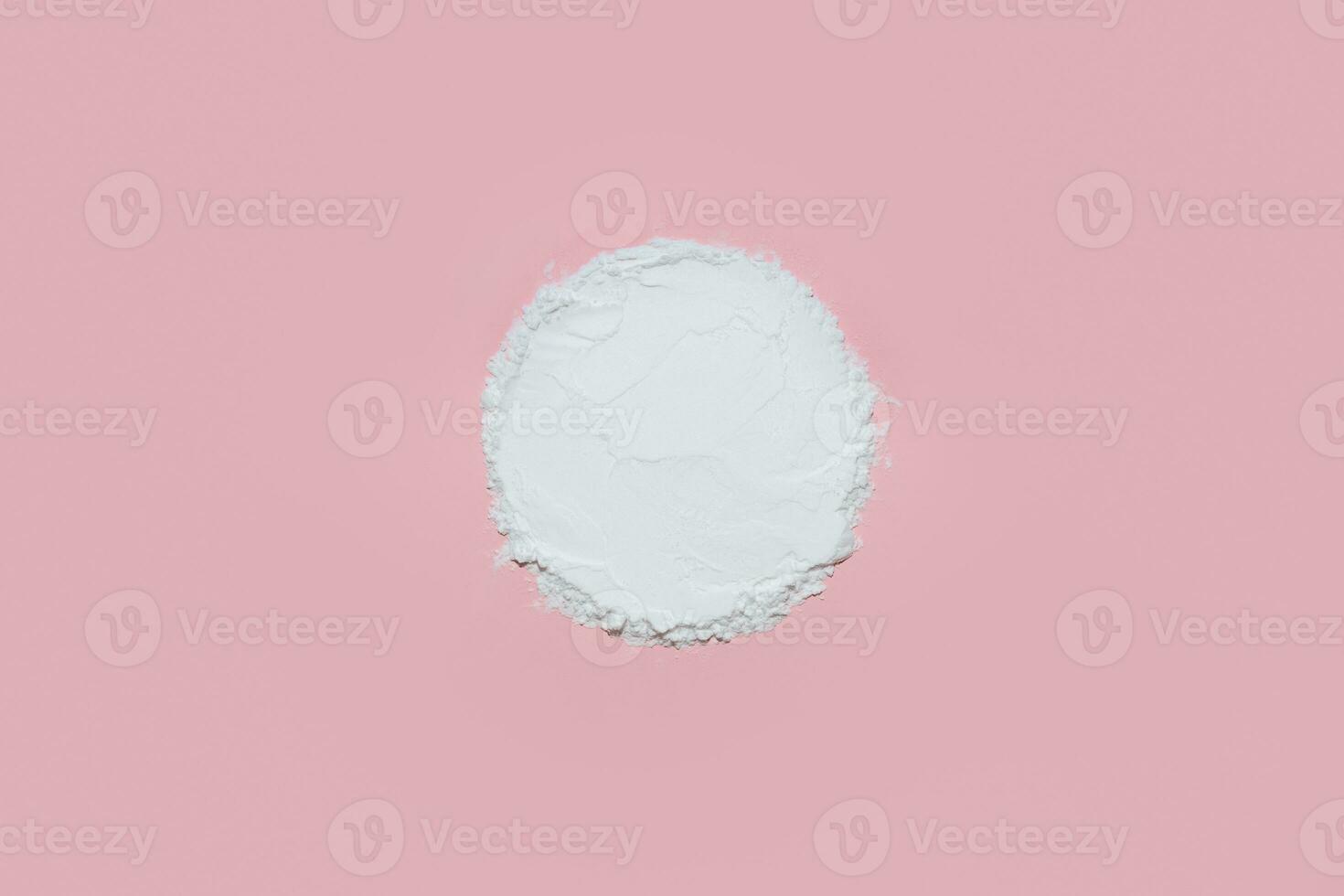 White face powder with empty circle inside on pink background photo