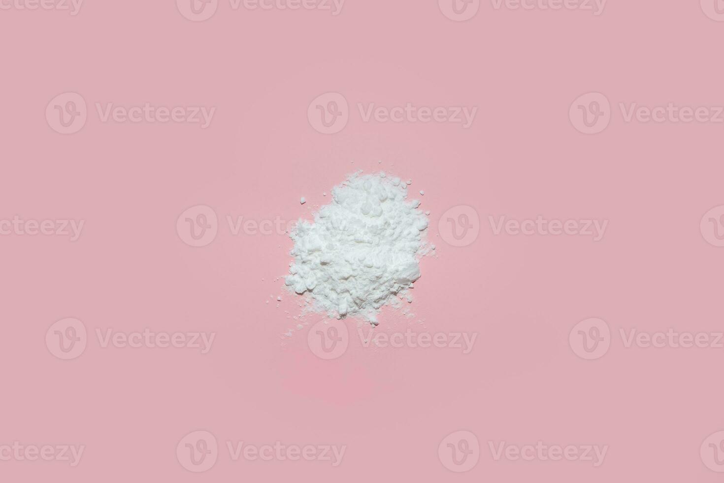 White face powder on pink background photo