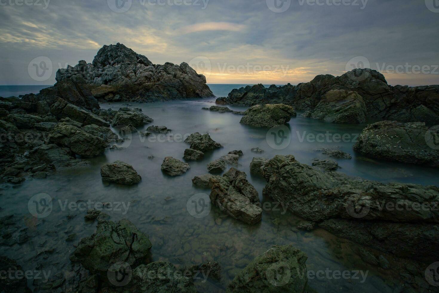 rocky beach with rocks and water at sunrise photo