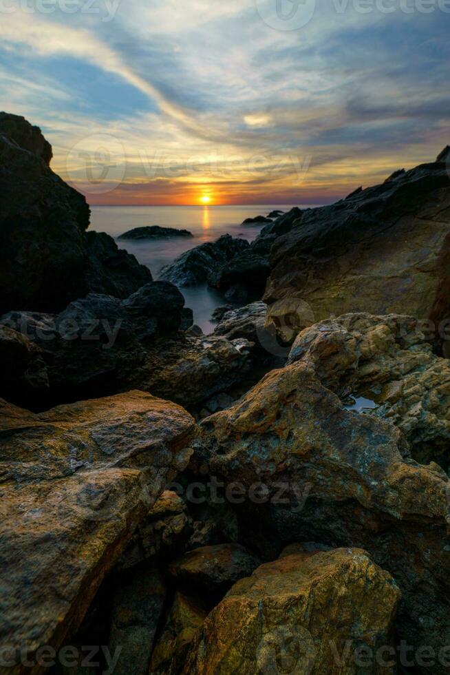 sunset over the ocean with rocks at Chanthaburi, Thailand. photo