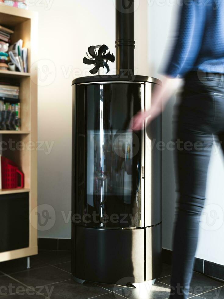 Woman walking near pellet stove in living room with library photo