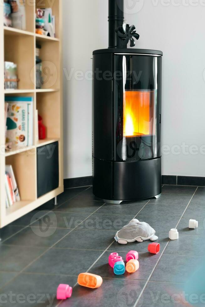 Pellet stove with some toys in front, with flames and library photo