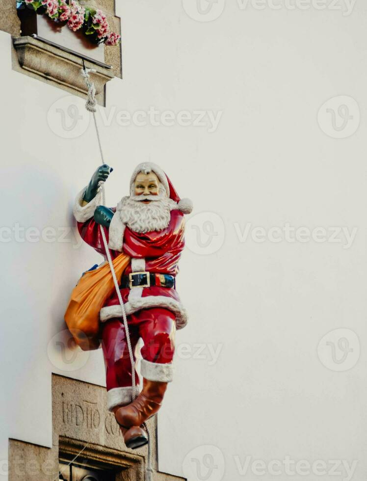 Decorative Santa Claus figure hanging from a facade photo