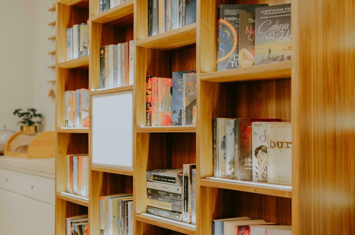The library, Pakuwon Trade Center,  Surabaya, Indonesia, August 19, 2023 - Side view of books arranged on wooden library shelves. Educational background. photo