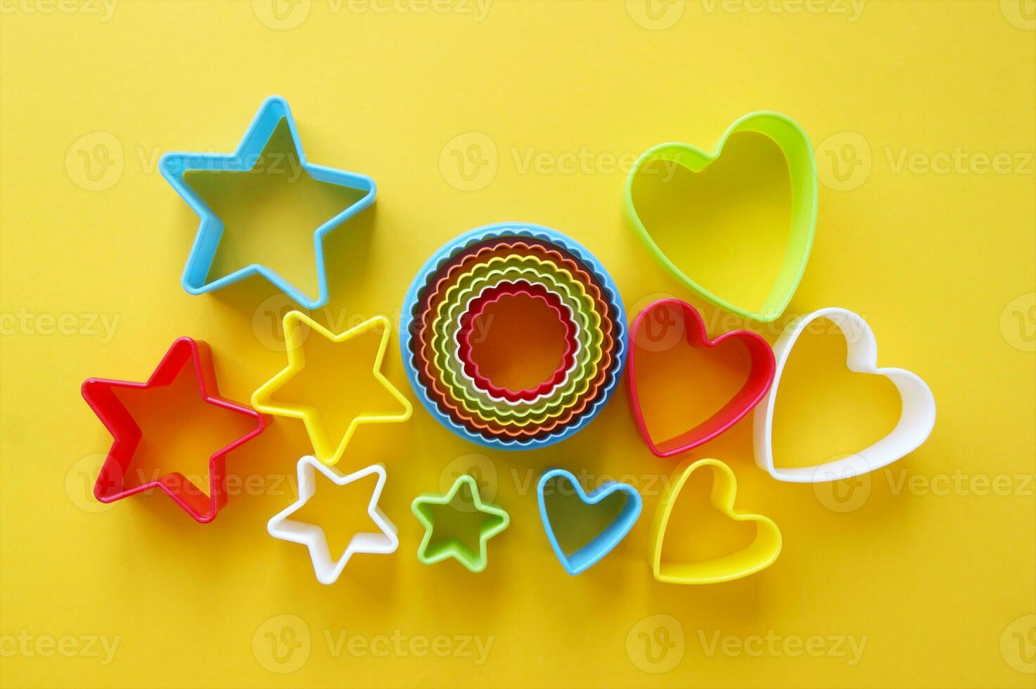 Plastic molds of multi colors for making cookies in the shape of a openwork circle, stars and hearts. photo