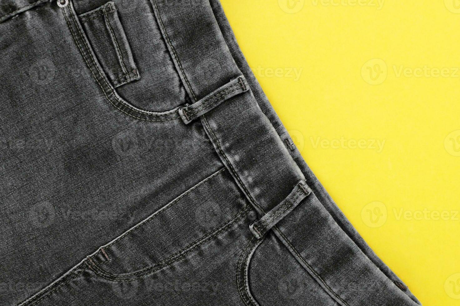 Flat lay, black jeans detail, background texture. photo