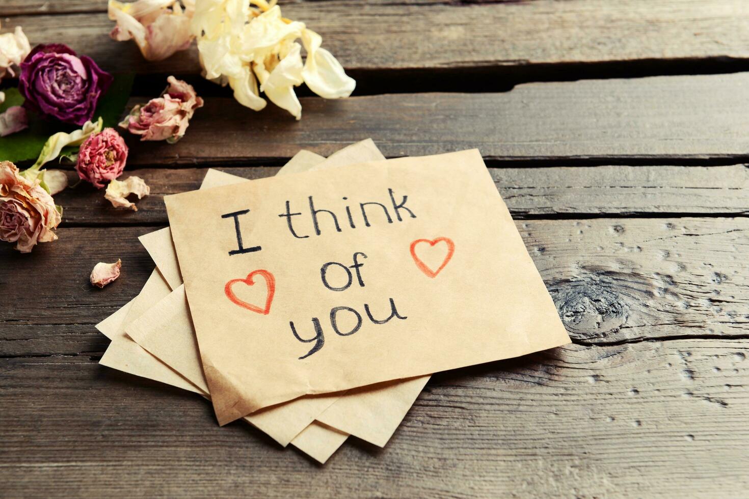 A Written Message with Dry Flowers on a Wooden Table photo