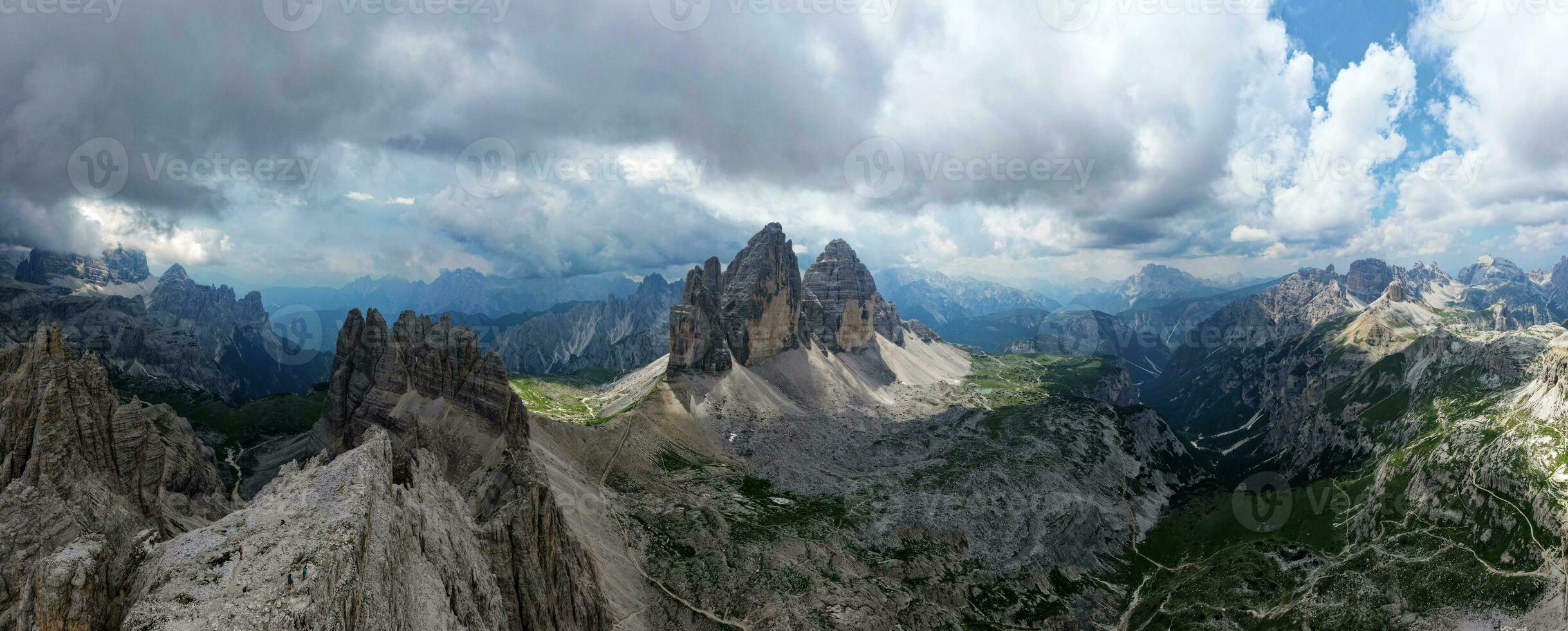 Aerial panoramic view of Tre Cime di Lavaredo mountain during a sunny day with clouds and fog in the Dolomites, Italy. Dramatic and cinematic landscape. very famous places for hiking and rock climbing photo