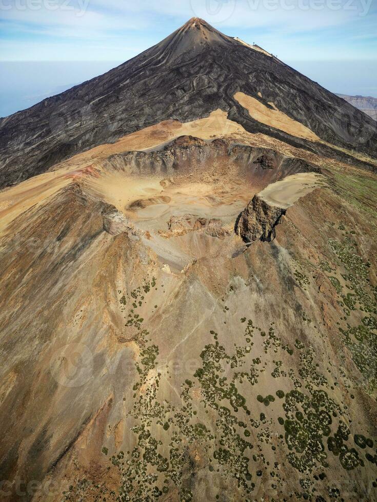 Aerial view of Pico Viejo volcano with Mount Teide in the background in Tenerife, Canary Islands, Spain. Pico Viejo has a spectacular 800 meters diameter crater. Famous destinations for hikers. photo