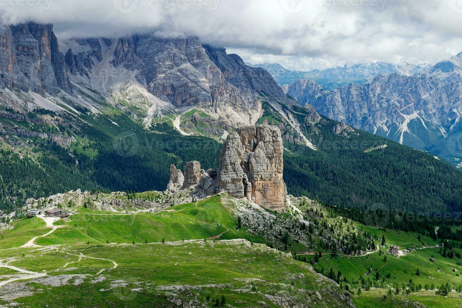 View of Cinque Torri with the Tofane mountain in the background covered with clouds. Famous climbing and alpinist place in the Dolomites, Italy. Travel destinations. photo