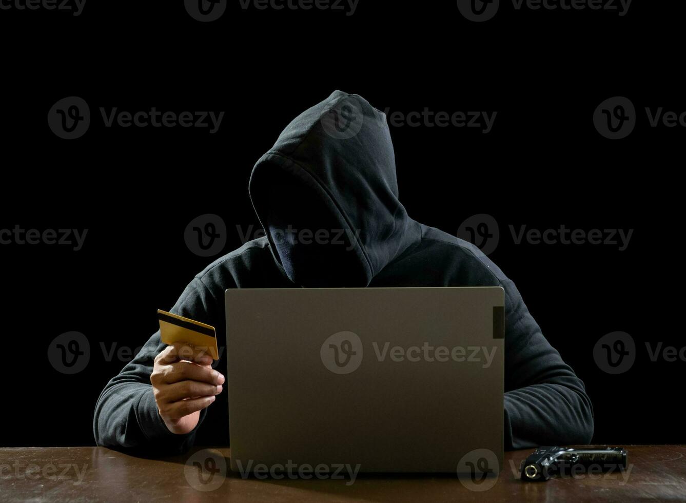 Portrait hacker spy man one person in black hoodie sitting on table looking computer laptop used login password attack security to data digital internet network system night dark background copy space photo