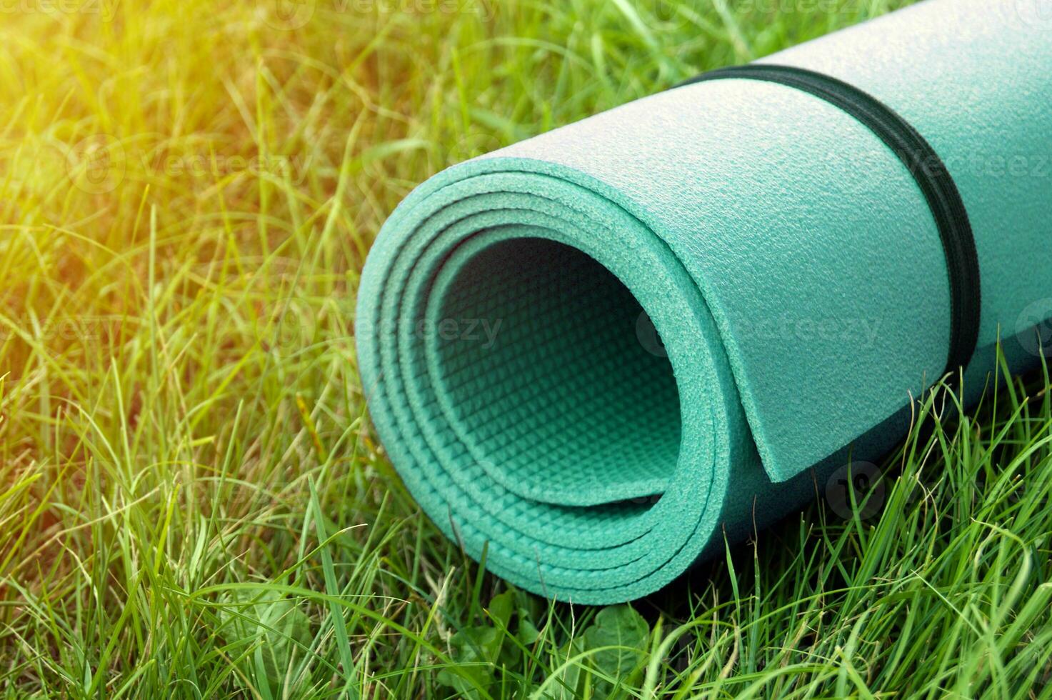 Yoga, fitness or tourist mat on the green grass. photo