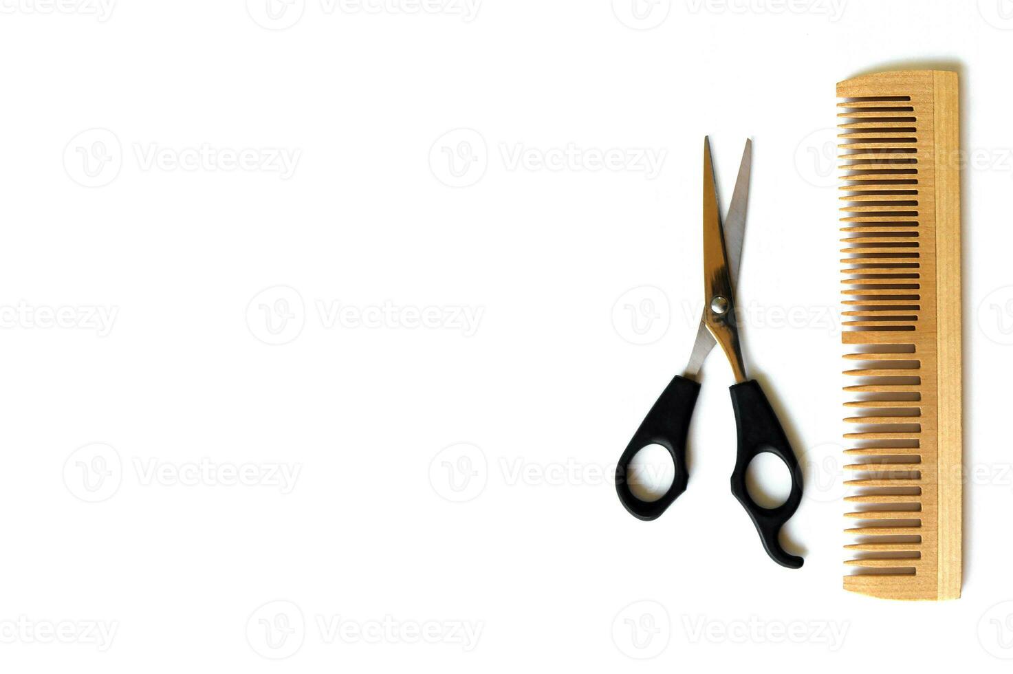Wooden comb and scissors for a haircut isolated on a white background. photo