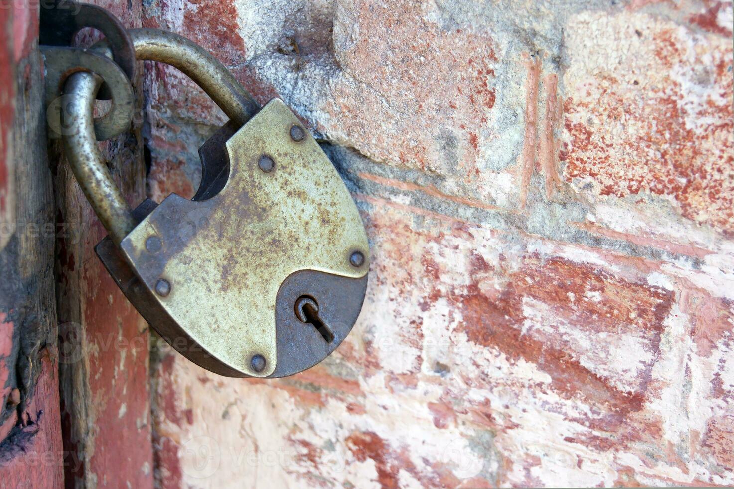 An old padlock on closed doors, a rusty lock on the gate. photo