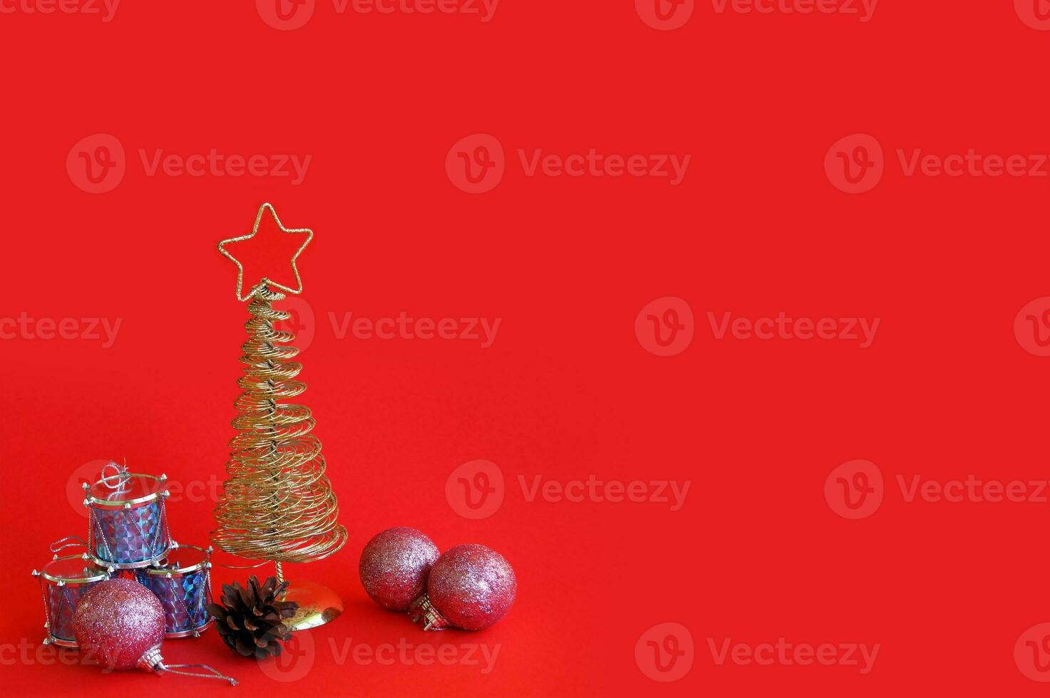 Golden metal Christmas tree with a star on top, red background. photo