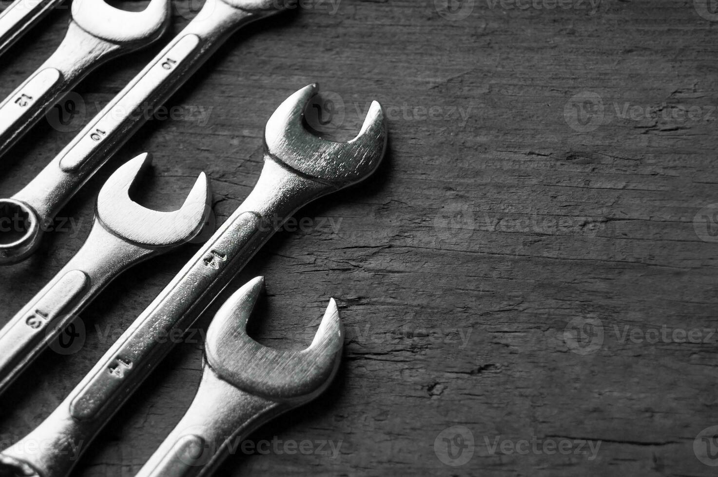 Wrenches of different sizes isolated on wood background photo