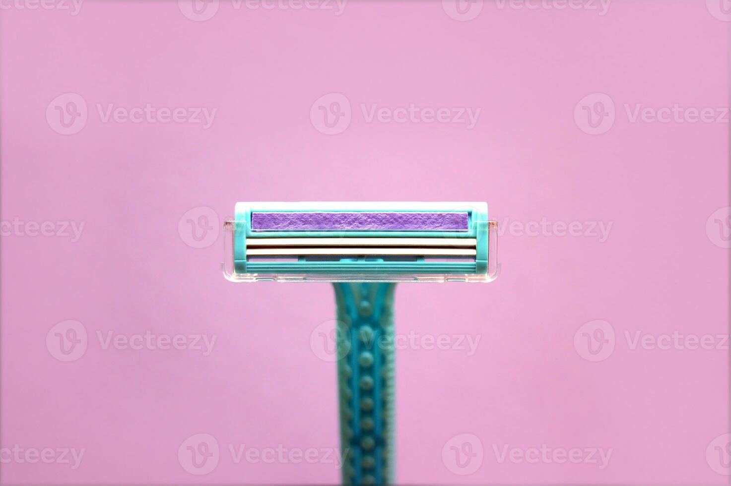 Closeup view with selective focus of disposable shaver isolated on abstract pink background. photo