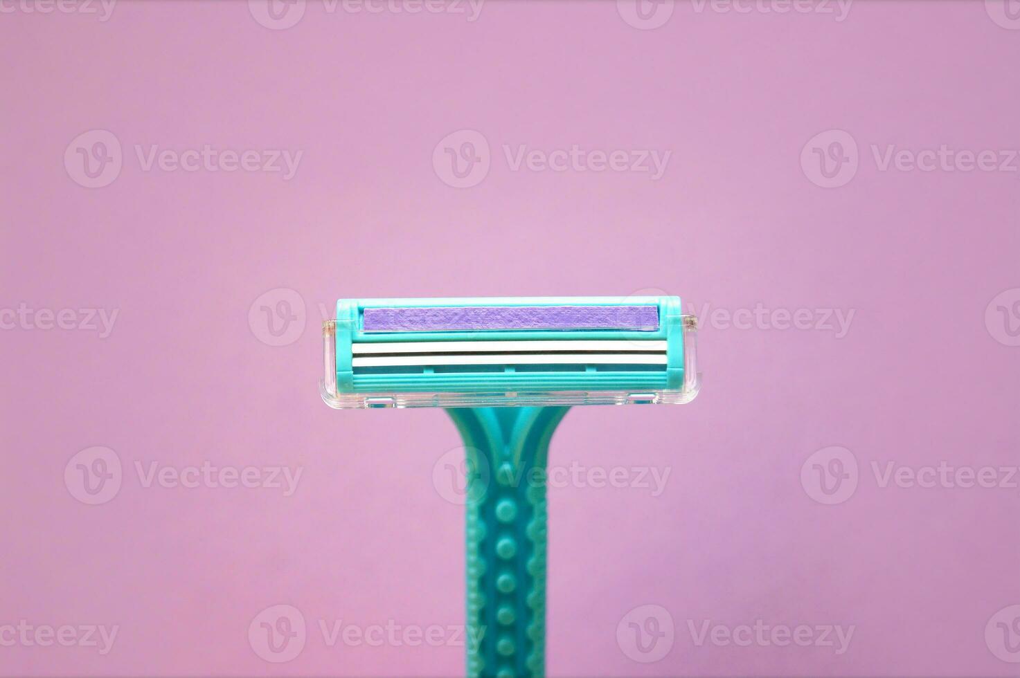 Closeup view with selective focus of disposable shaver isolated on abstract pink background. photo