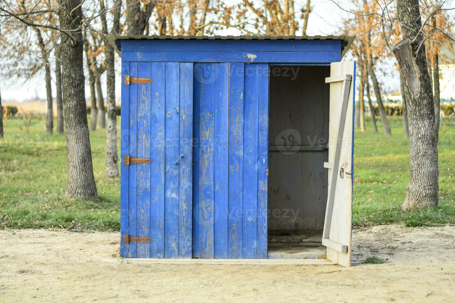 Public toilet in a street park. Blue wooden toilet, restroom. photo