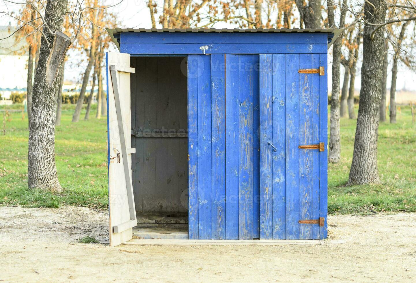 Public toilet in a street park. Blue wooden toilet, restroom. photo