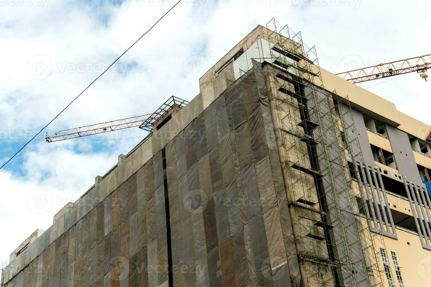 Several large canvases stretch together, Covered building under construction photo