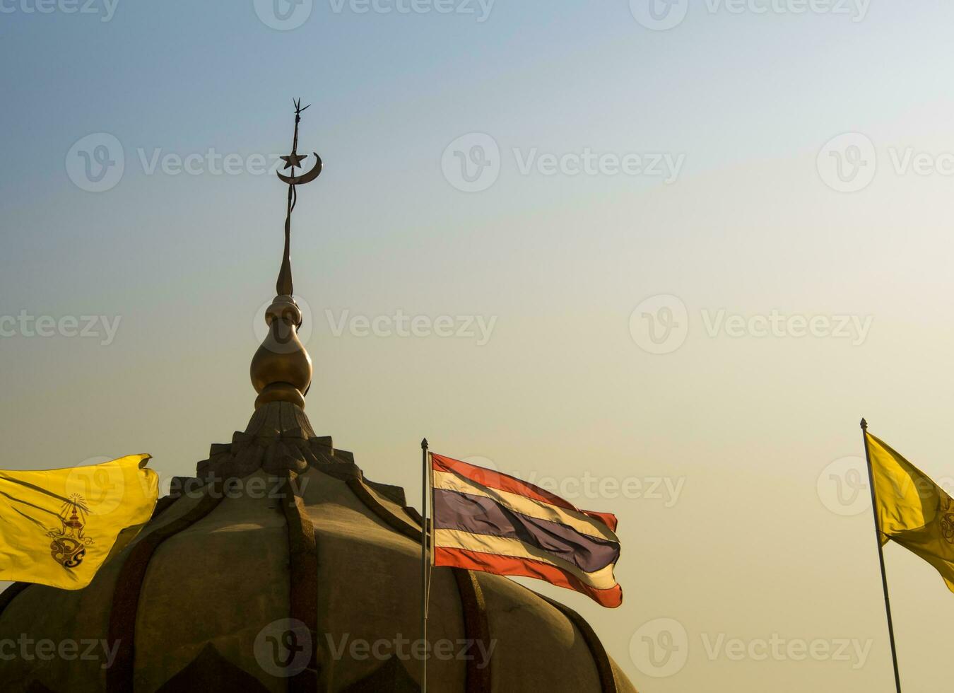 Thai flag and the flag of the king in front of the mosque building with evening sky photo