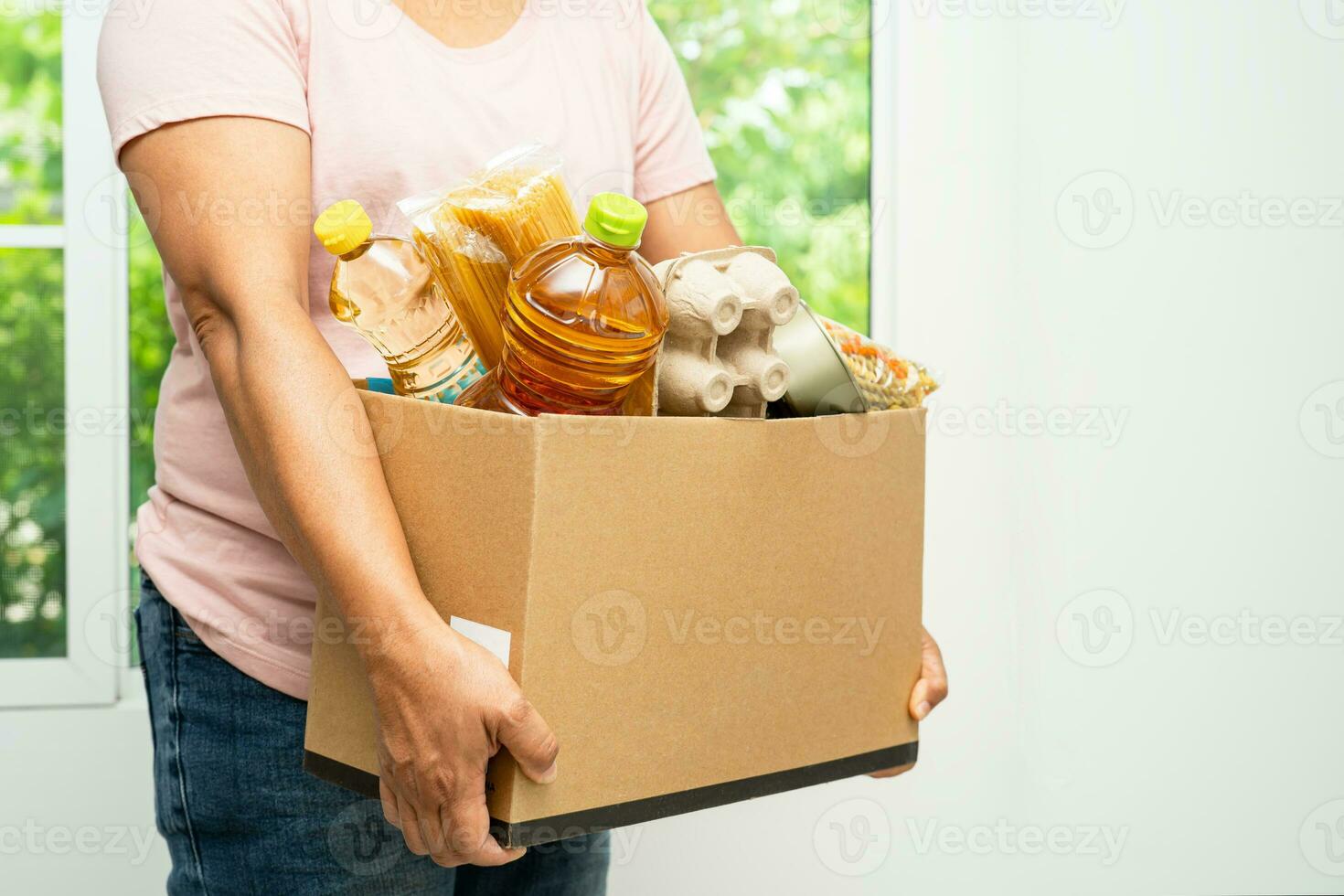 voluntarios poniendo varios alimentos secos en cajas de donación para ayudar a las personas. foto