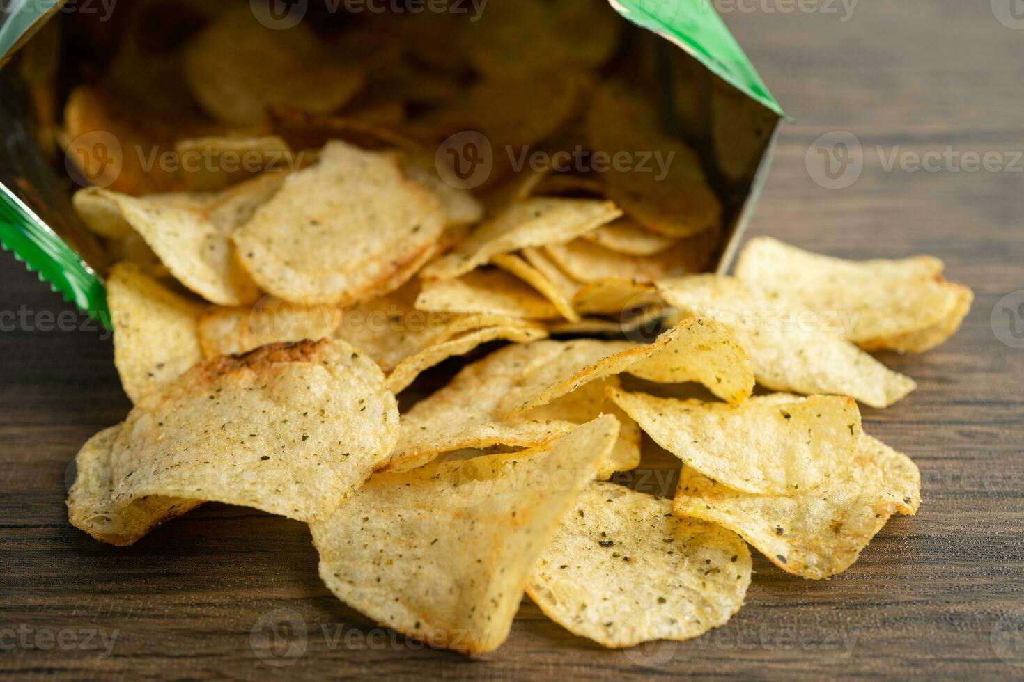 Potato chips, delicious spicy for crips, thin slice deep fried snack fast food in open bag. photo