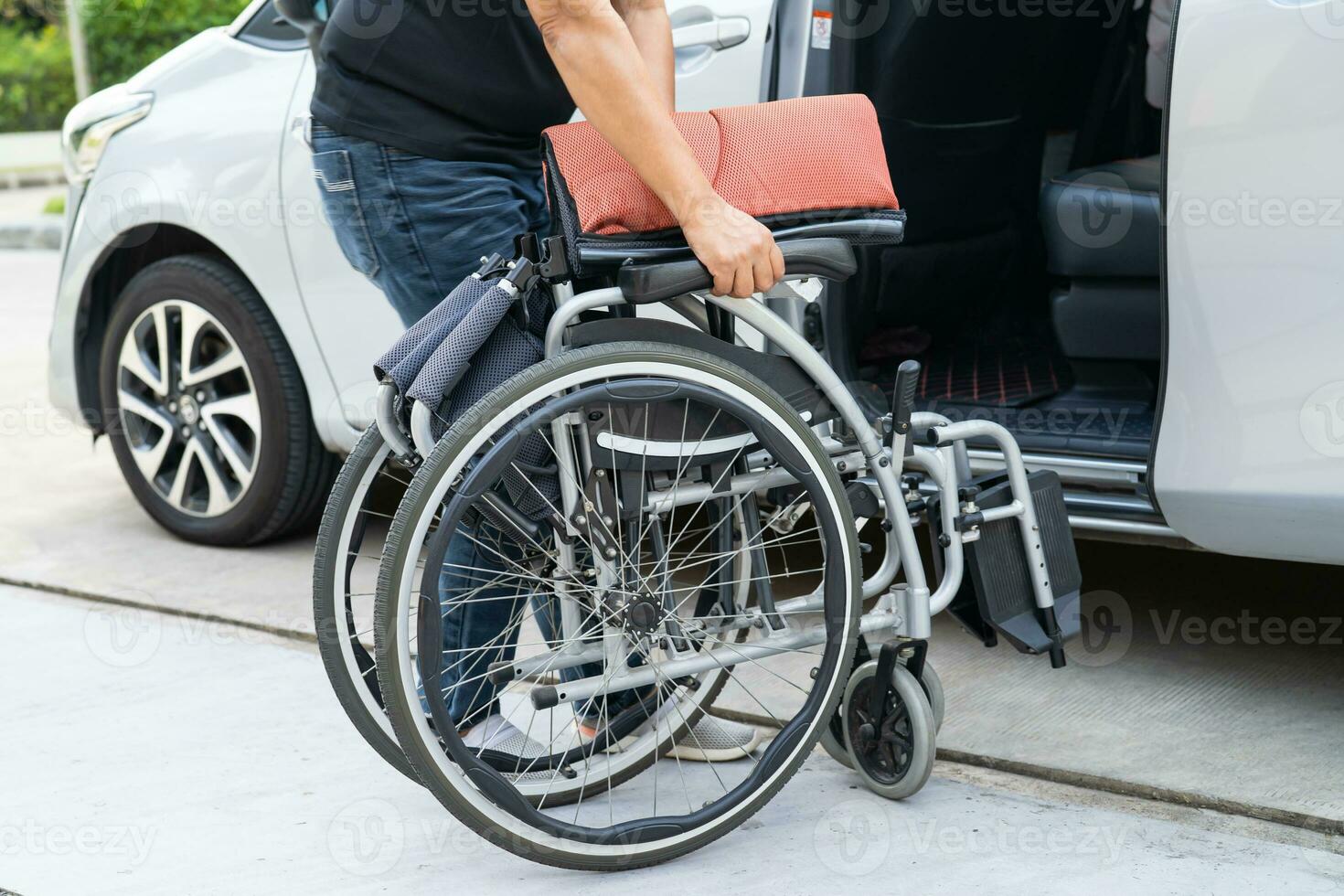 asiático invalidez mujer en silla de ruedas consiguiendo en su auto, accesibilidad concepto. foto