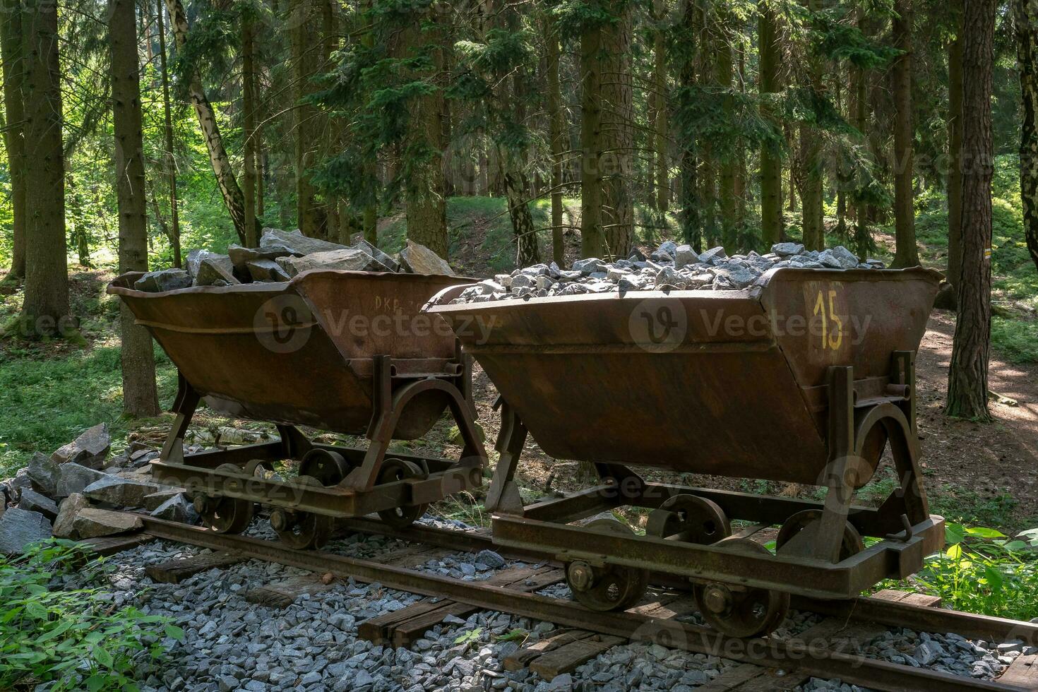 Mining cart with stones. Old and abandoned mining cart in forest. photo