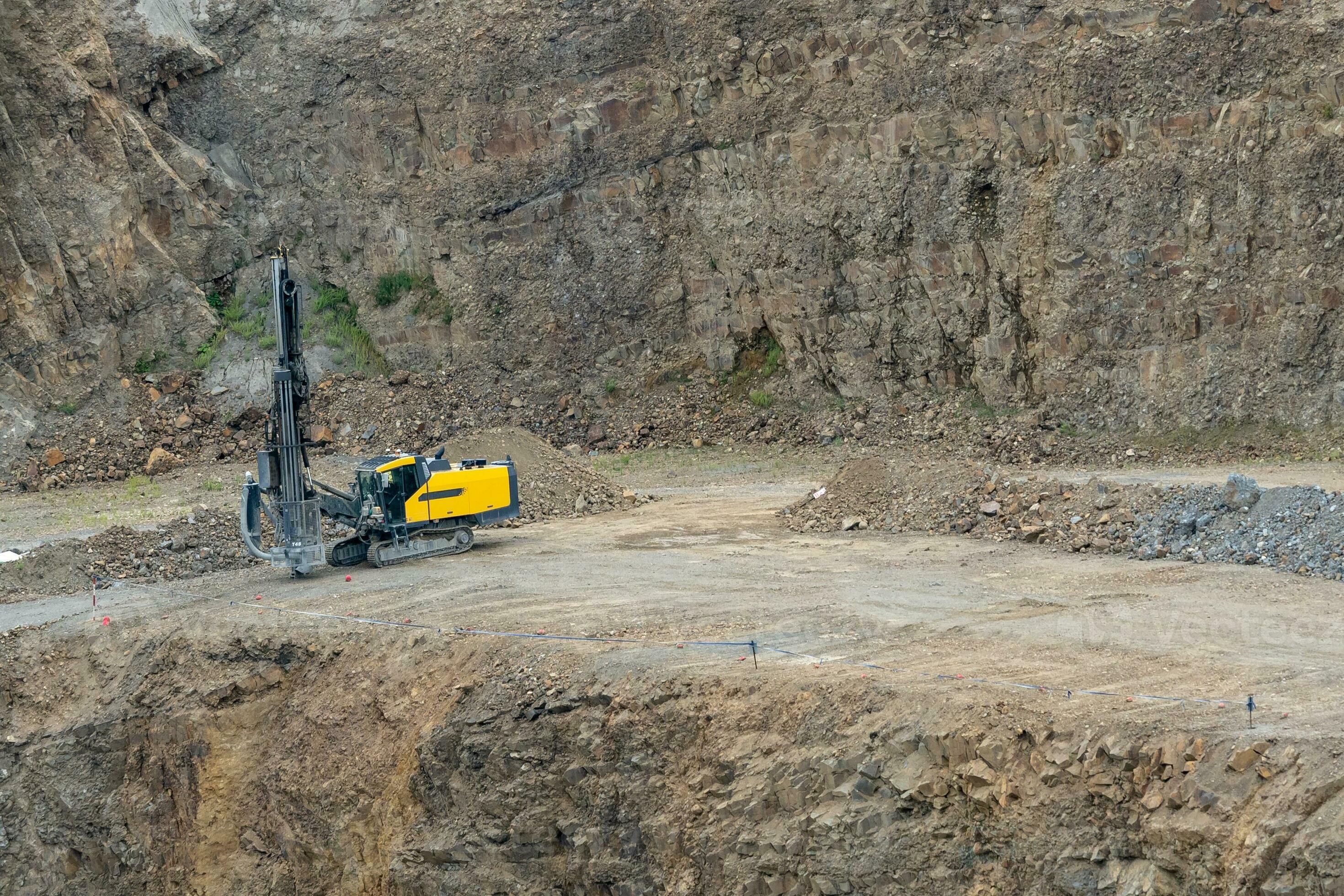 Opencast mining quarry with mining drilling machine. Mining in the granite quarry. Mining