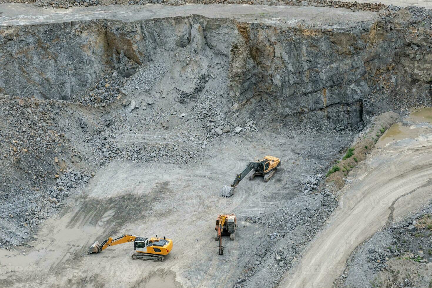 Mining in the granite quarry. Working mining machine - digger. Mining industry. photo