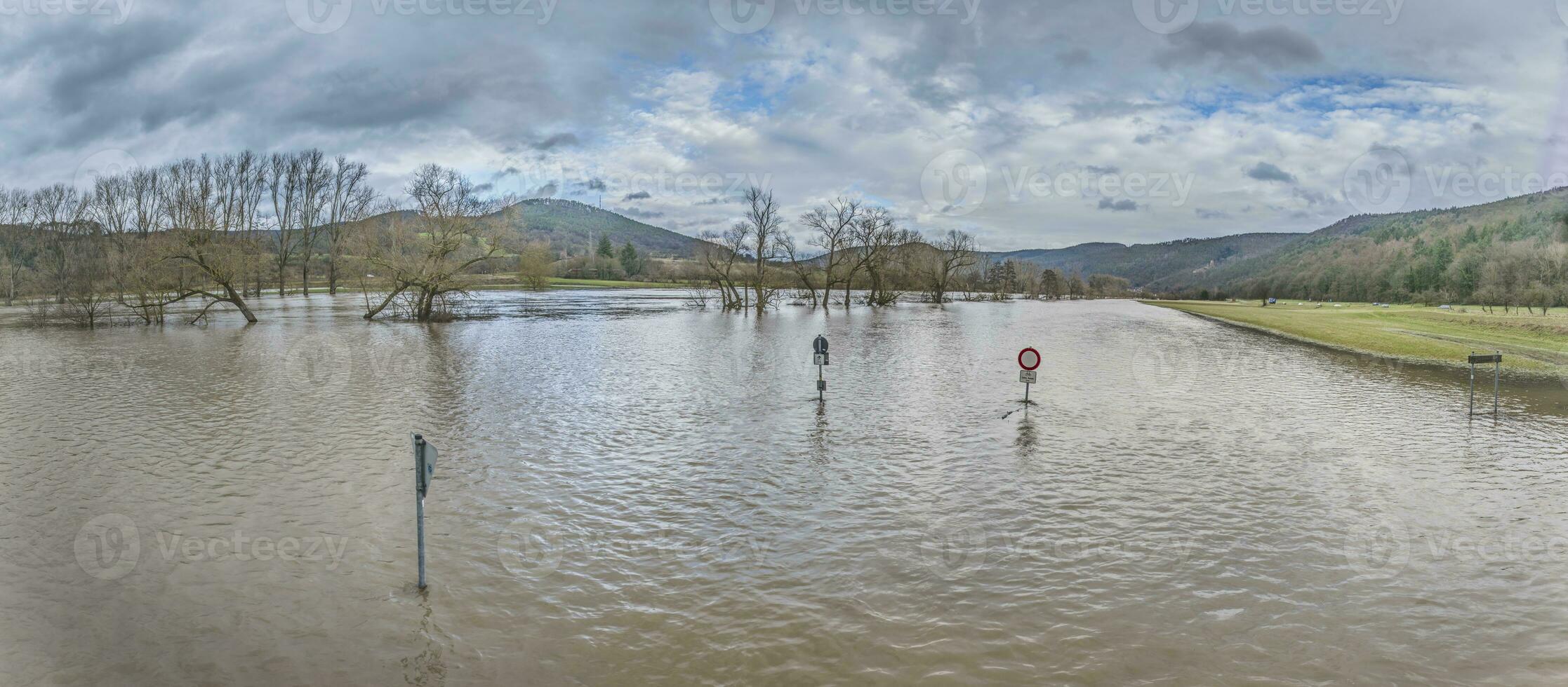 Drone image of the German river Main during a flood with flooded trees and traffic signs on the bank photo