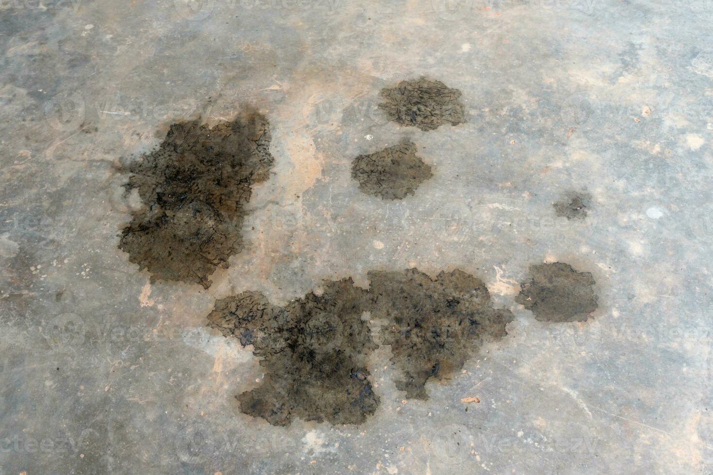 Oil stain or slick spilled from cars on dirty gray concrete floor or garage floor. dirty concrete background texture. photo