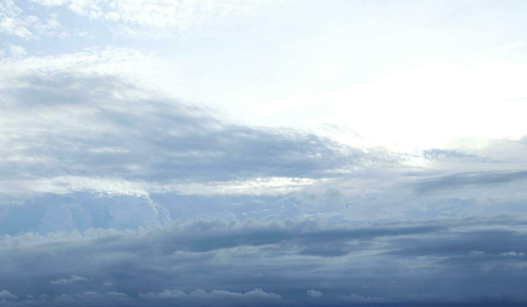 Gray clouds cover white and bright sky background. photo