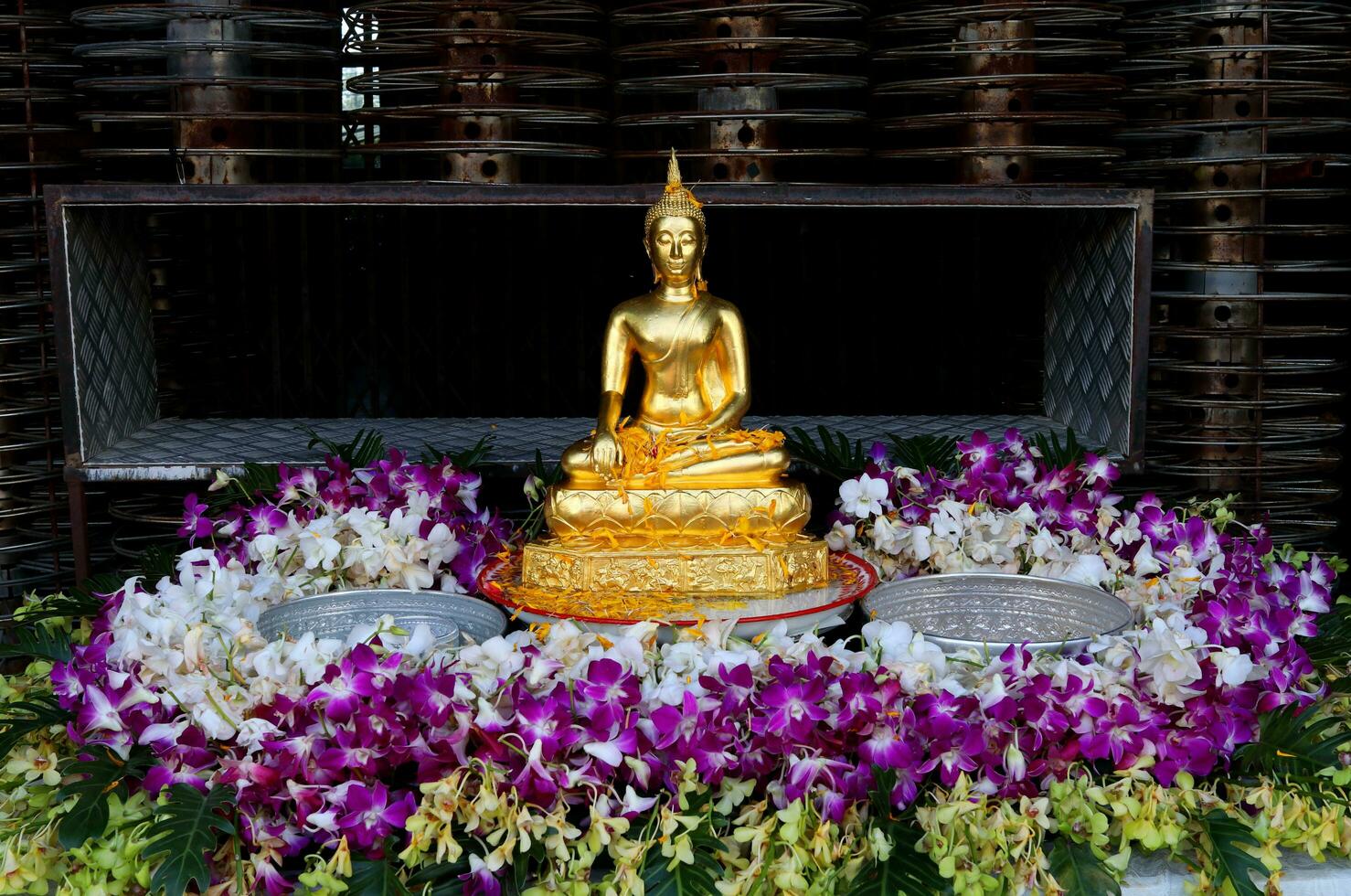 oro Budda estatua Decorar rodeado variedad color orquídeas para torrencial agua en mesa al aire libre en Songkran festival en tailandia foto