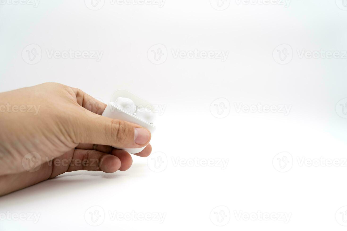 Hands holding wireless headphones. Truly Wireless Headset On An Open Charging Case. Selective focus. Copy Space. photo