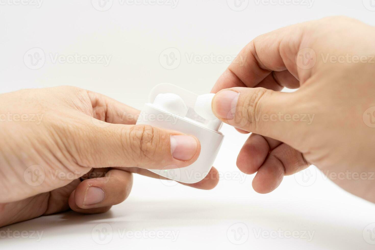 Hands holding wireless headphones. Truly Wireless Headset On An Open Charging Case. Selective focus. Copy Space. photo