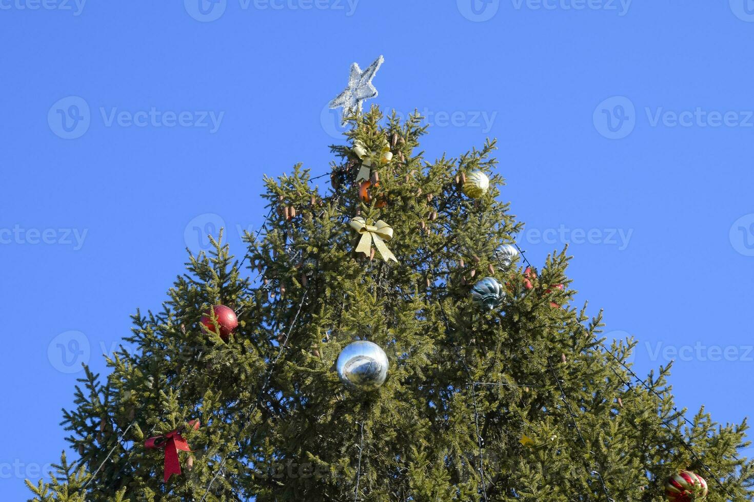 decoraciones nuevo año árbol. oropel y juguetes, pelotas y otro decoraciones en el Navidad Navidad árbol en pie en el abierto aire. foto