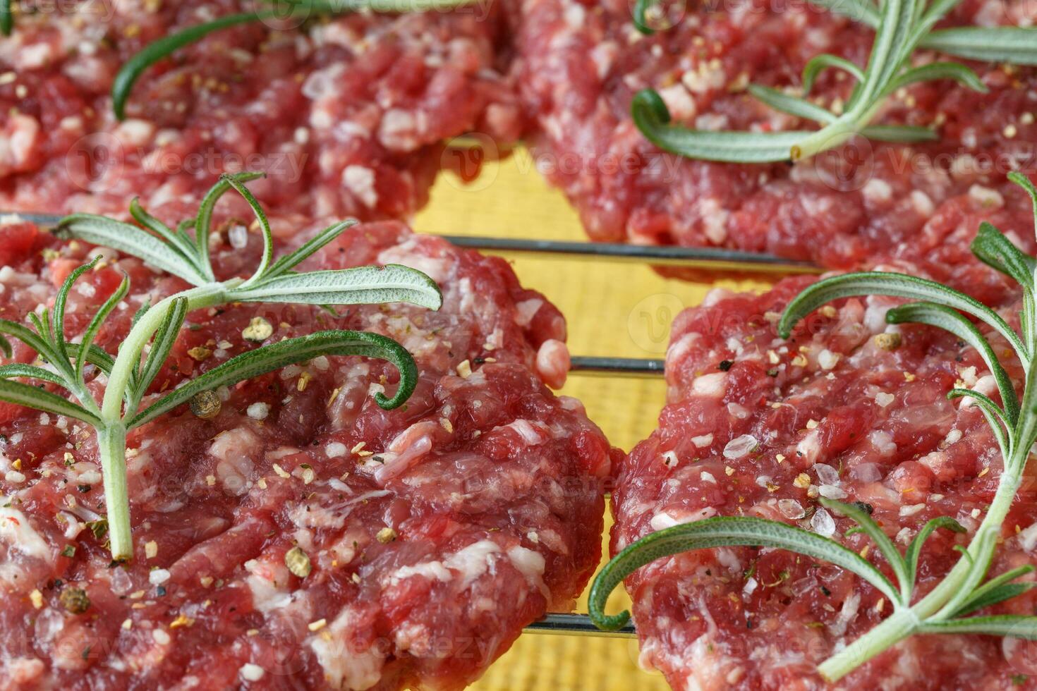 Raw minced hamburger meat with herb and spice prepared for grilling photo