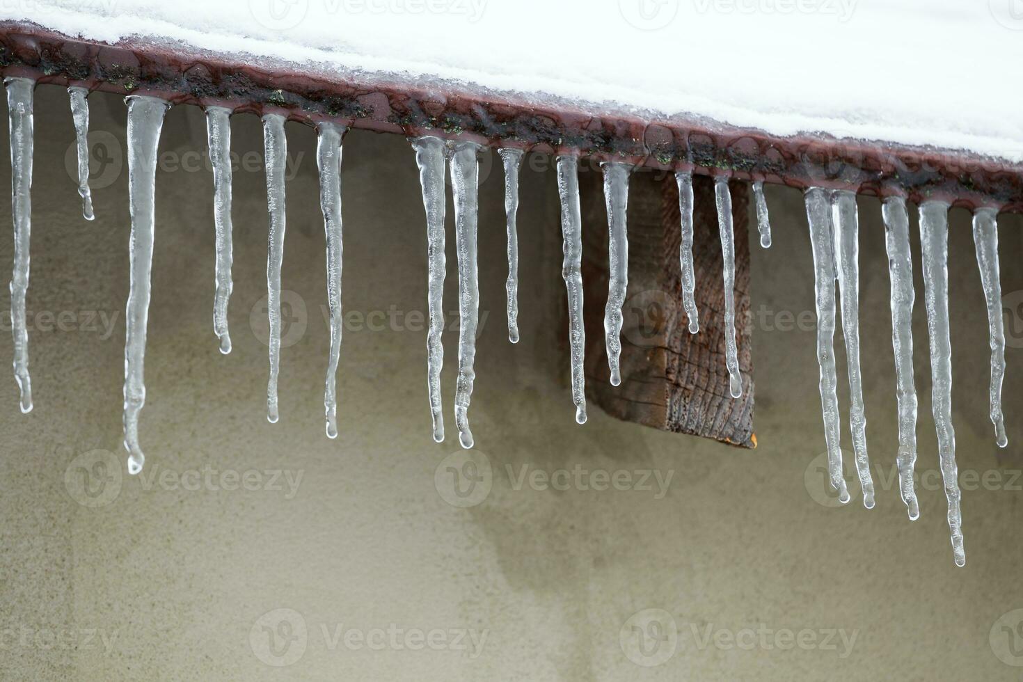 Icicles which are hanging down from a roof photo