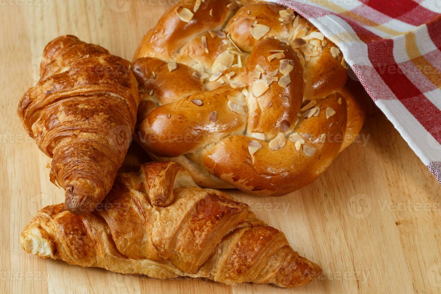 sabroso croissants y pasteles en de madera antecedentes foto