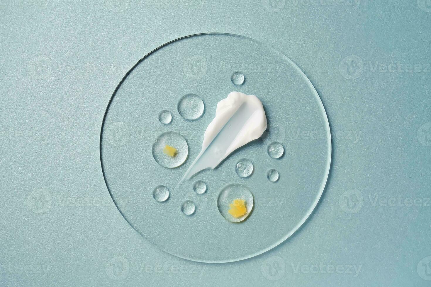 Gel, serum and a cream on a transparent round stand on a blue background. photo