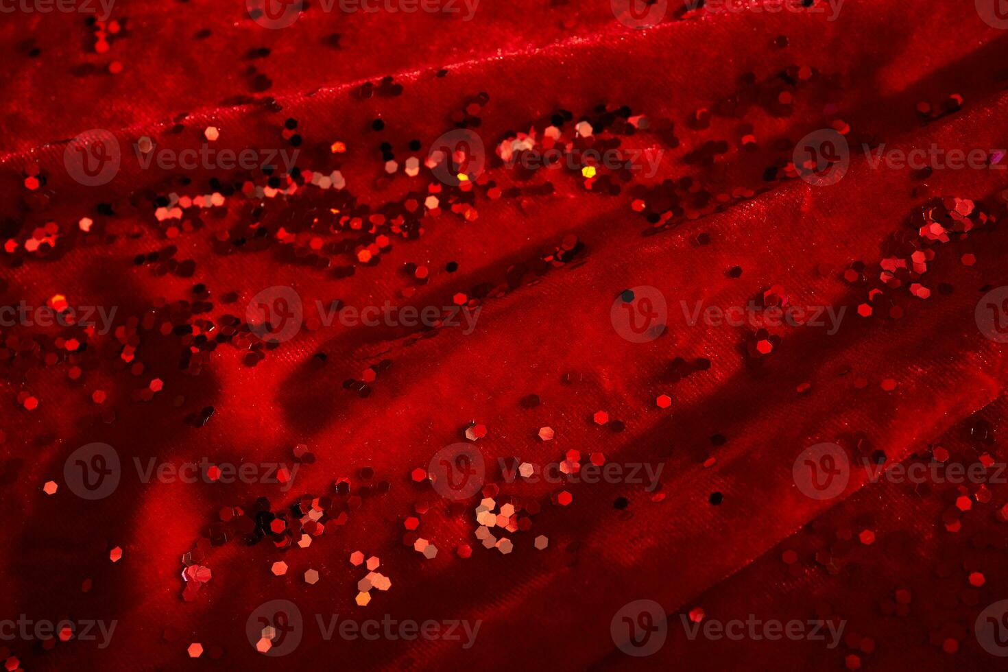 Abstract Christmas background made of red velvet fabric with red sparkles. photo
