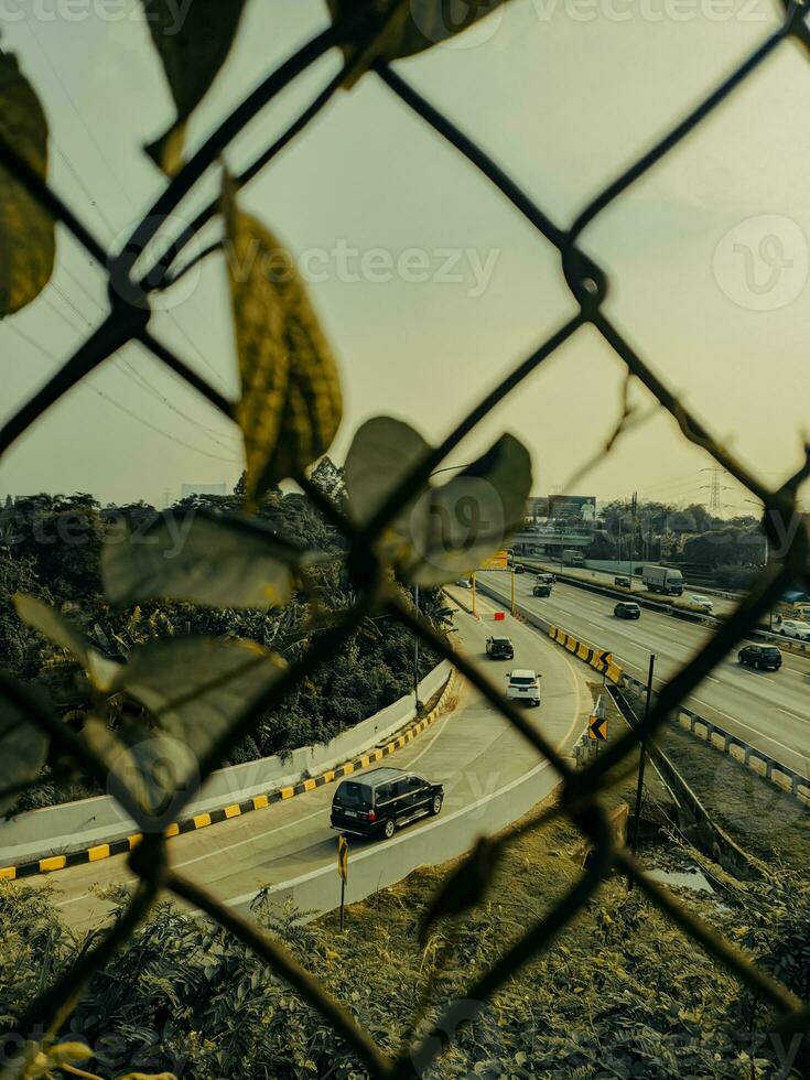 a view of a highway through a chain link fence photo