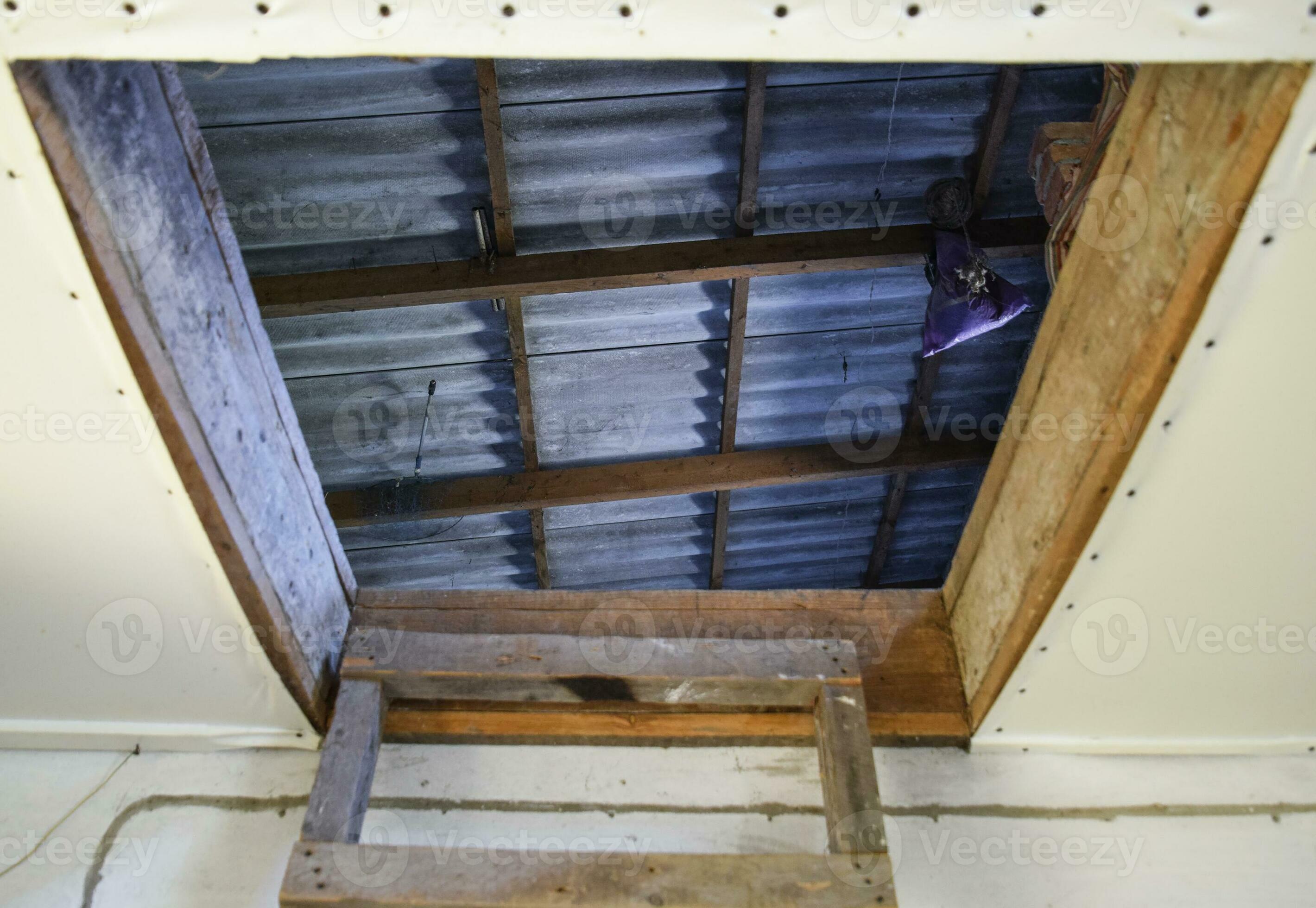 Open the entrance to the attic. The staircase and the door to the attic of the house 36115526