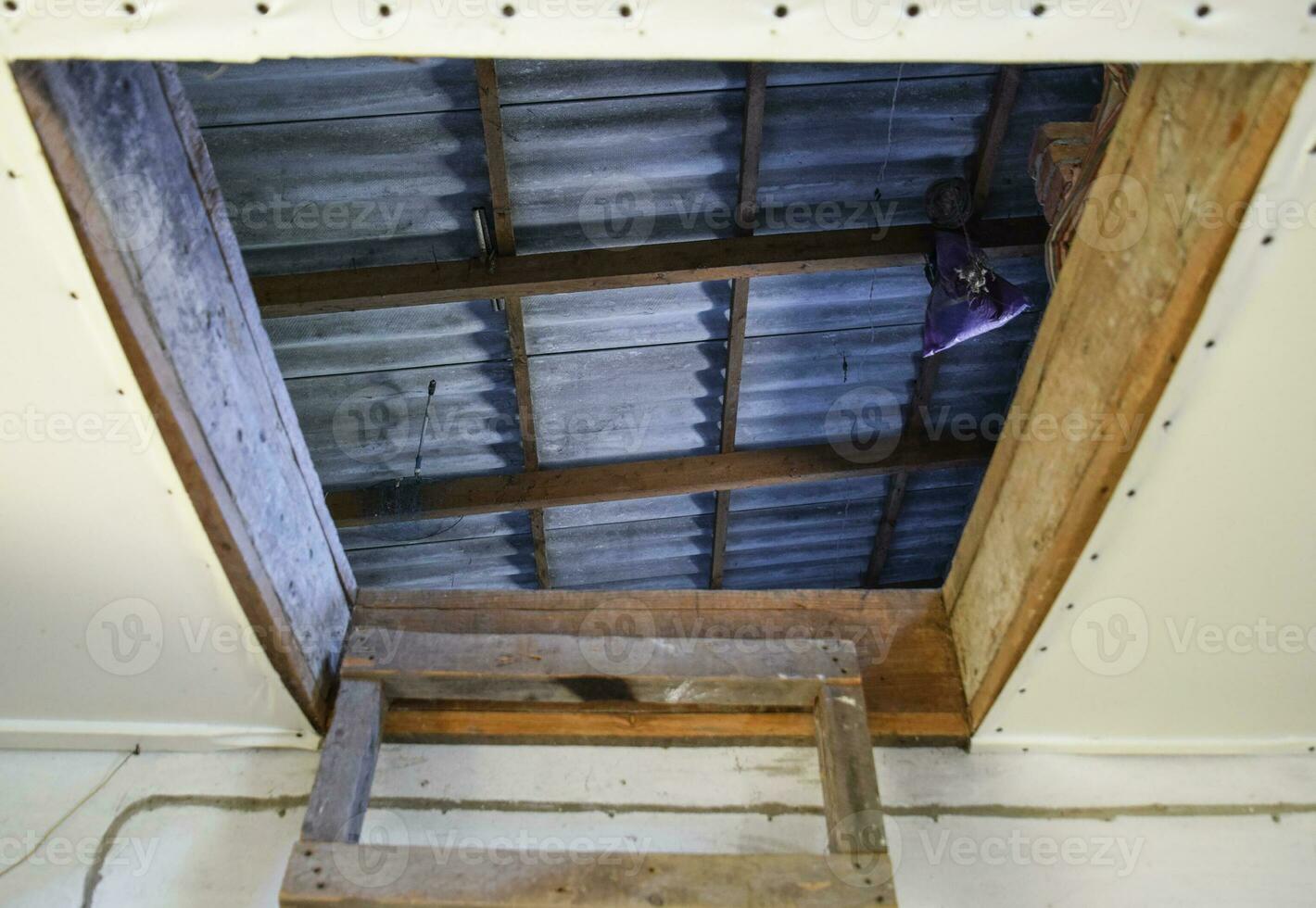 Open the entrance to the attic. The staircase and the door to the attic of the house photo