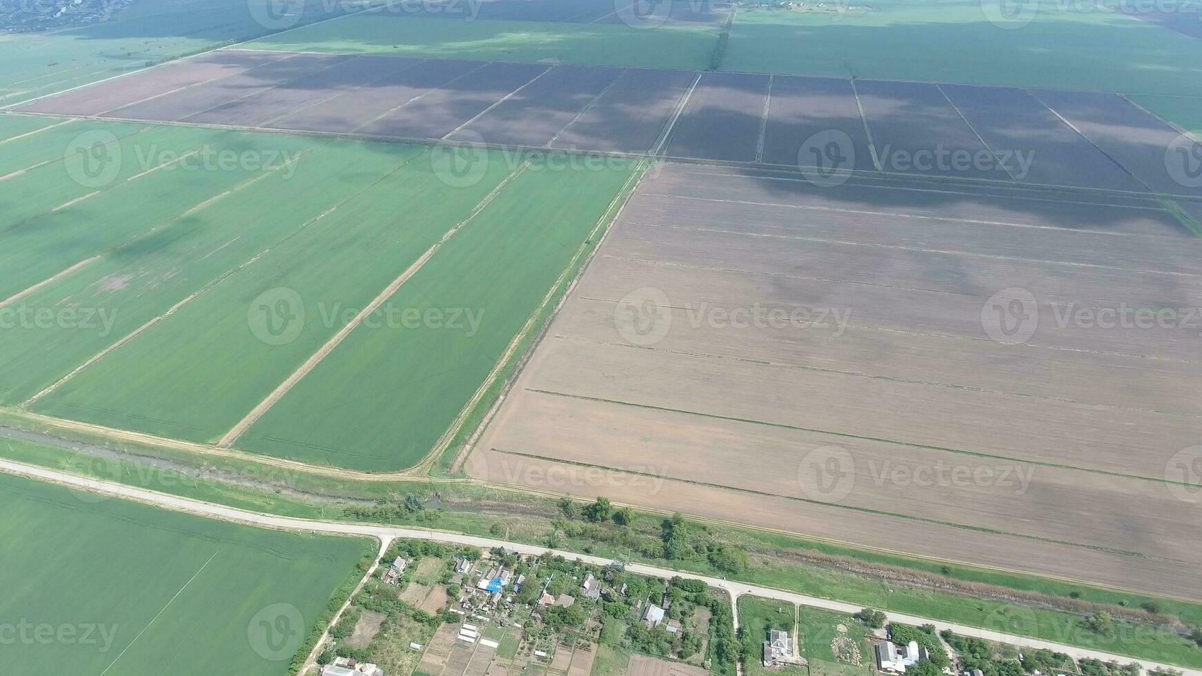 Fields in the Kuban view from a height. Young wheat and plowed field a little further from the village. photo