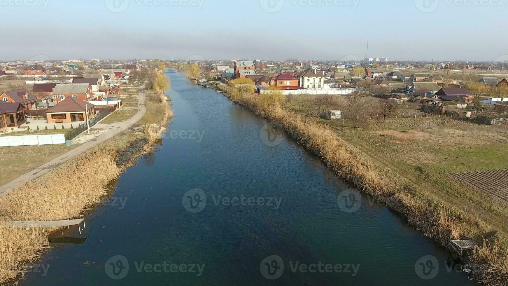 River eric current in the village in the spring. Shallow river, slowly flowing in the village. photo
