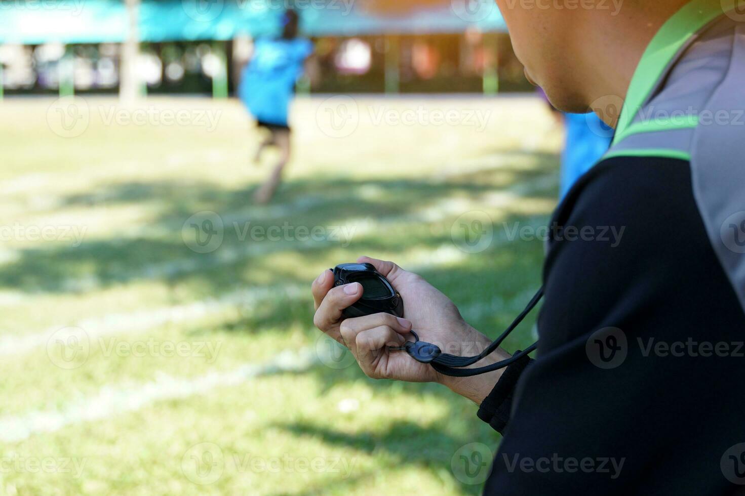 entrenador cronometrado el terminar línea con un cronógrafo a determinar el ganador de el colegio Deportes día corriendo evento. suave y selectivo enfocar. foto